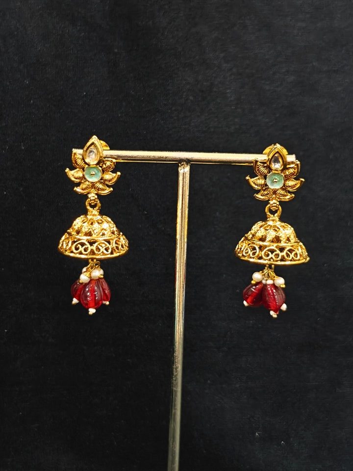 Close-up of an ornate traditional Rajwadi gold Long jewellery set and earrings with Kundan, Coloured Beads and pearls. Wedding guest styling a Rajwadi artificial necklace with a Saree. Festive look completed with a luxury Rajwadi imitation necklace.