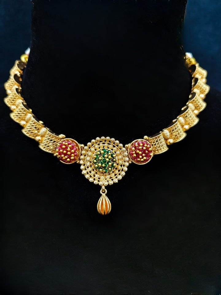 Close-up of an ornate traditional (Gold Polish) Collar jewellery set and earrings with Crystal Beads. Woman wearing trending artificial Colored Stone jewelry for wedding season in India. Saree look completed with elegant artificial Colored Stone jewelry for festive occasions.