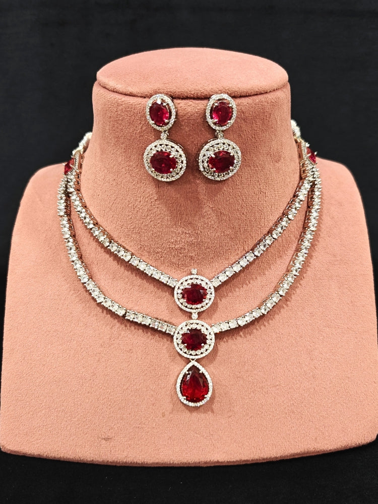 An elegant artificial diamond necklace with red colored stone and matching earrings. This premium artificial diamond jewelry set is perfect for special occasions, from Indian weddings to engagement parties, offering sophisticated glamour without the high price tag.