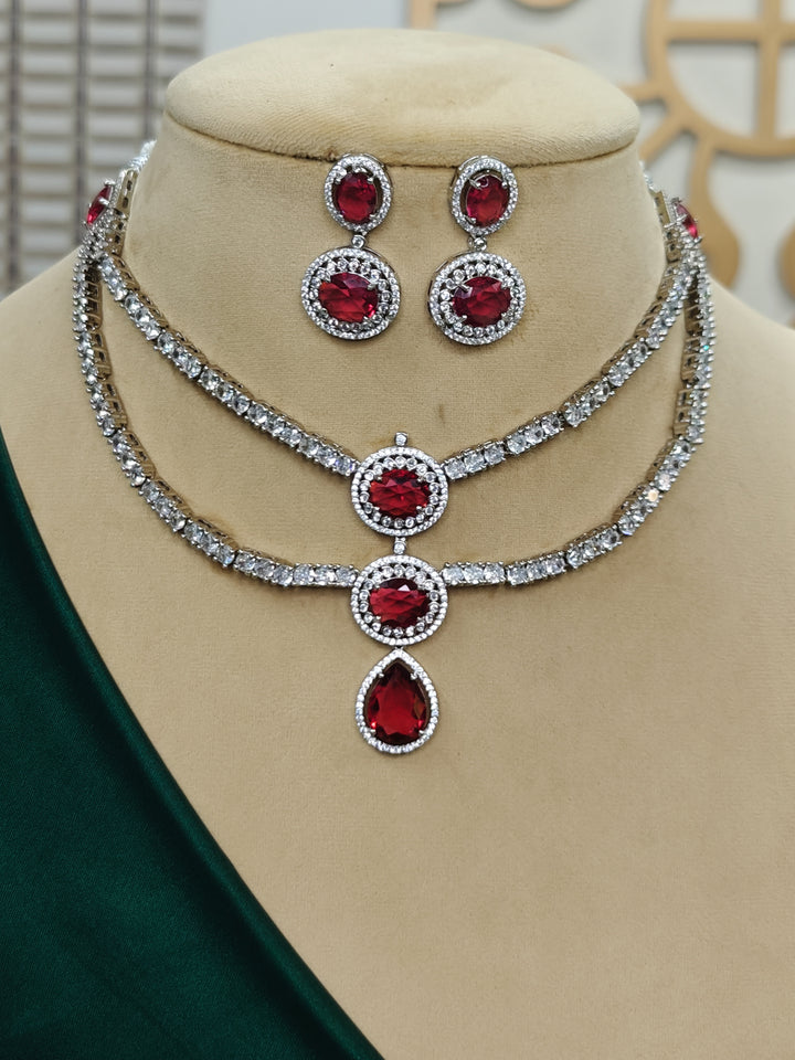 "A bride-to-be wearing an exquisite artificial diamond necklace with red colored stone and matching earrings, designed for the perfect engagement look. This stunning artificial diamond jewelry set offers luxury and sophistication while being an affordable alternative to natural diamonds."
