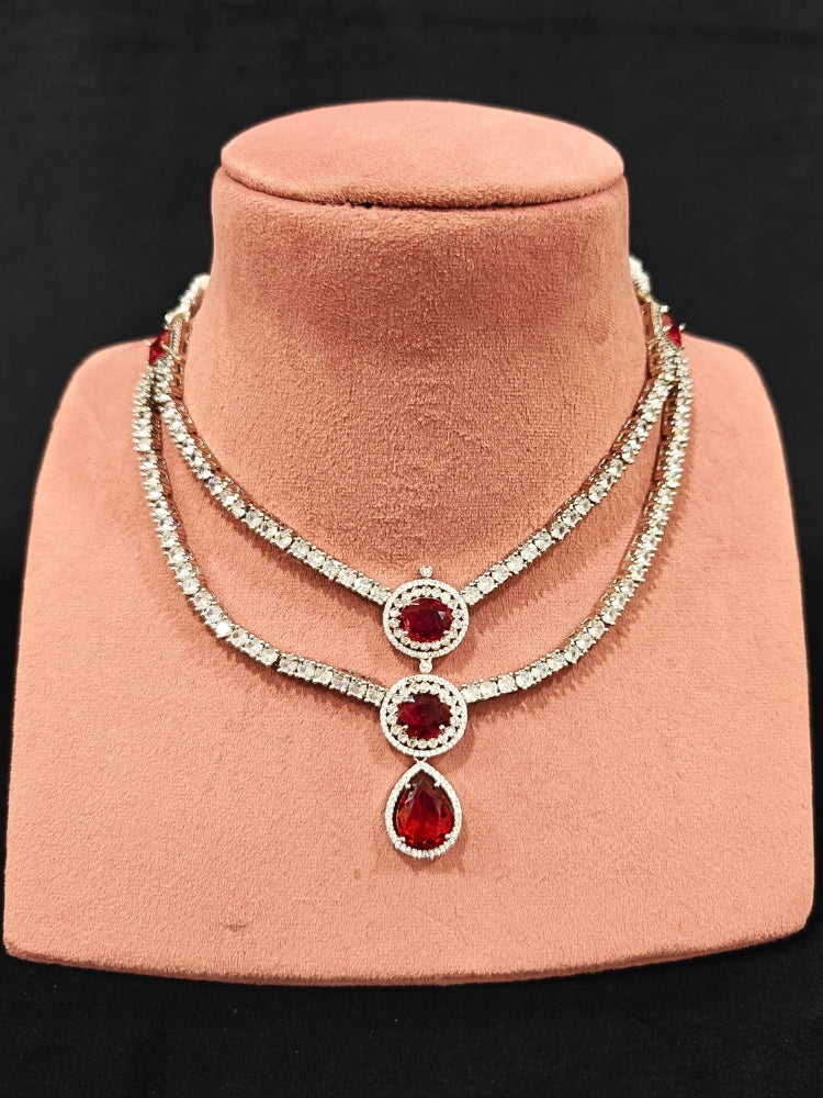 An elegant artificial diamond necklace with red colored stone and matching earrings. This premium artificial diamond jewelry set is perfect for special occasions, from Indian weddings to engagement parties, offering sophisticated glamour without the high price tag.