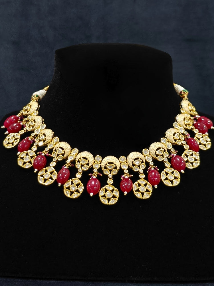 Close-up of an ornate traditional (Gold Polish) Collar Red jewellery set and earrings with Polki, Meenakari and Red Tumble Beads.Festive saree look completed with a Polki artificial jewelry set. Woman wearing a lightweight Polki jewelry set for long wedding functions.