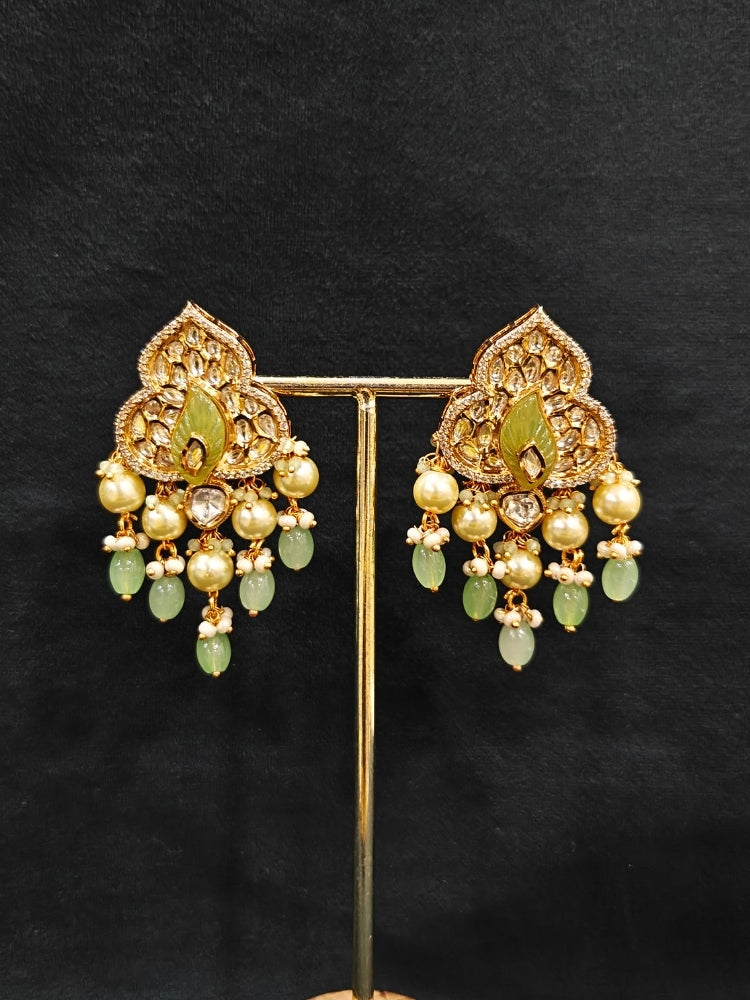 Close-up of an ornate traditional (Gold Polish) Mint Green Long jewellery set and earrings with Polki, American Diamond Tumble Beads and Pearls. Woman wearing trending Polki artificial jewelry for the wedding season in India. Wedding guest outfit styled with an elegant Polki necklace set.