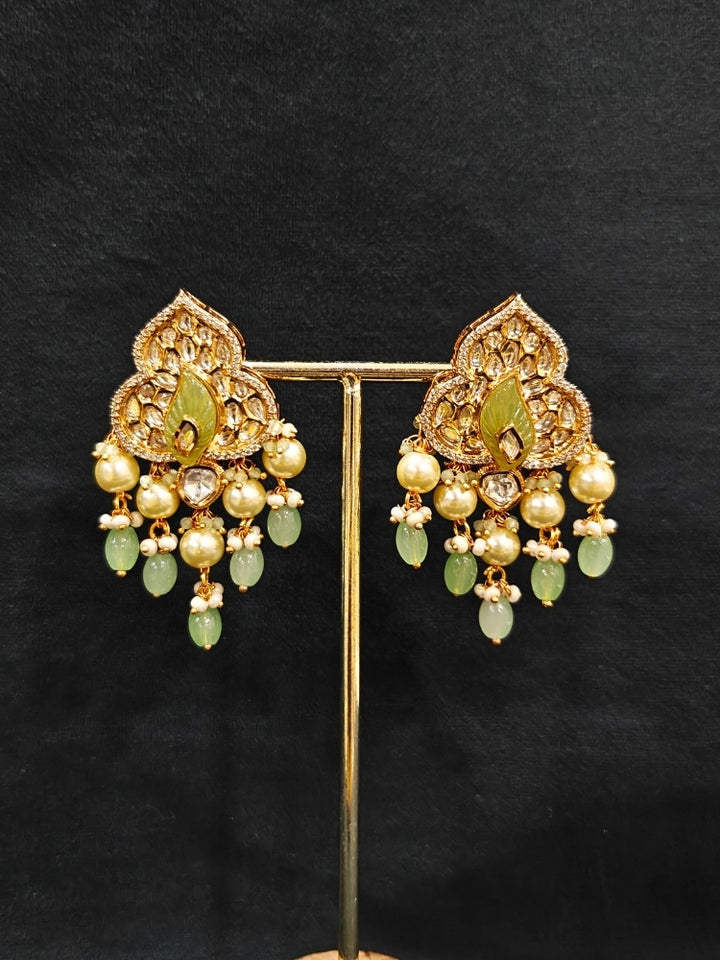 Close-up of an ornate traditional (Gold Polish) Mint Green Long jewellery set and earrings with Polki, American Diamond Tumble Beads and Pearls. Woman wearing trending Polki artificial jewelry for the wedding season in India. Wedding guest outfit styled with an elegant Polki necklace set.