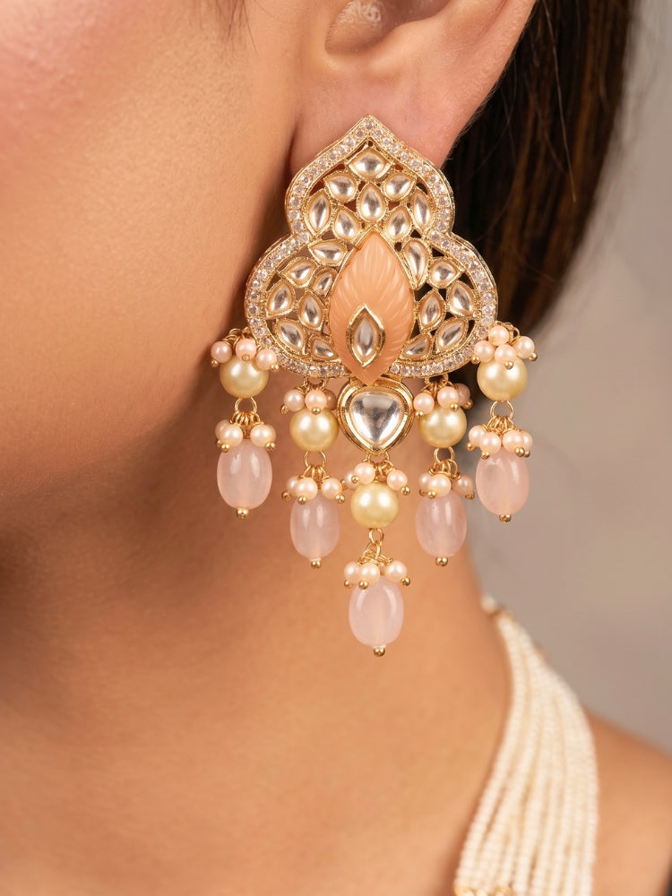 Close-up of a women wearing an ornate traditional (Gold Polish) Mint Pink Long jewellery set and earrings with Polki, American Diamond Tumble Beads and Pearls. Woman wearing trending Polki artificial jewelry for the wedding season in India. Wedding guest outfit styled with an elegant Polki necklace set.
