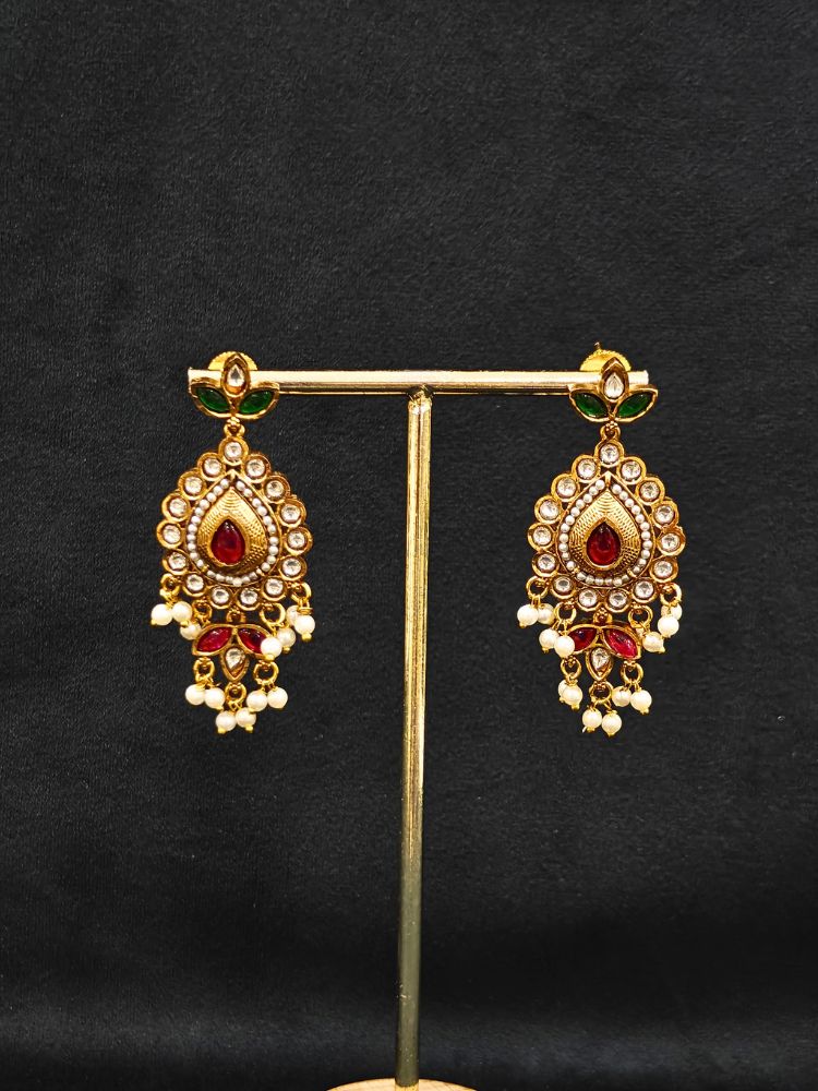 Close-up of an ornate traditional (Gold Polish) Choker White jewellery set and earrings with Pearl, Polki, Colored Stones, and crystal Beads. Woman wearing trending Polki artificial jewelry for the wedding season in India. Festive celebration look completed with premium imitation Polki jewelry.
