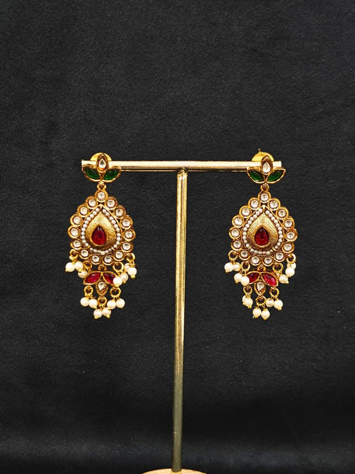 Close-up of an ornate traditional (Gold Polish) Choker White jewellery set and earrings with Pearl, Polki, Colored Stones, and crystal Beads. Woman wearing trending Polki artificial jewelry for the wedding season in India. Festive celebration look completed with premium imitation Polki jewelry.