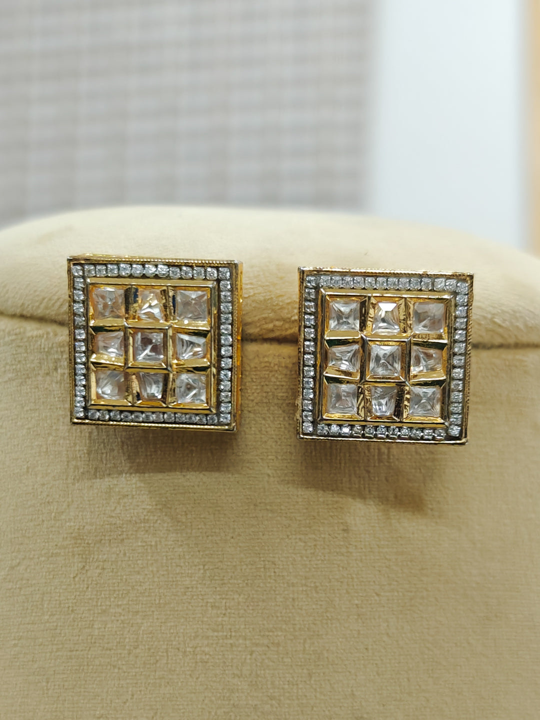 Close-up of an ornate traditional Kundan (gold polish) Studs Earrings with American Diamond and Kundan. Mehendi function outfit styled with a lightweight Kundan Studs Earrings. Saree look enhanced with a traditional  artificial Kundan Earrings.