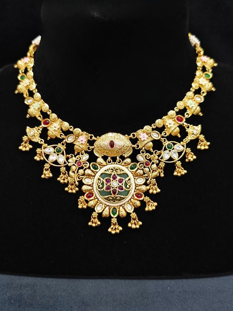 Close-up of an ornate traditional (Gold Polish) Collar jewellery set and earrings with Polki, Meenakari and Colored Stones. Festive Diwali outfit paired with a colorful Colored Stone necklace. Mehendi ceremony look completed with a Colored Stones jewelry set.