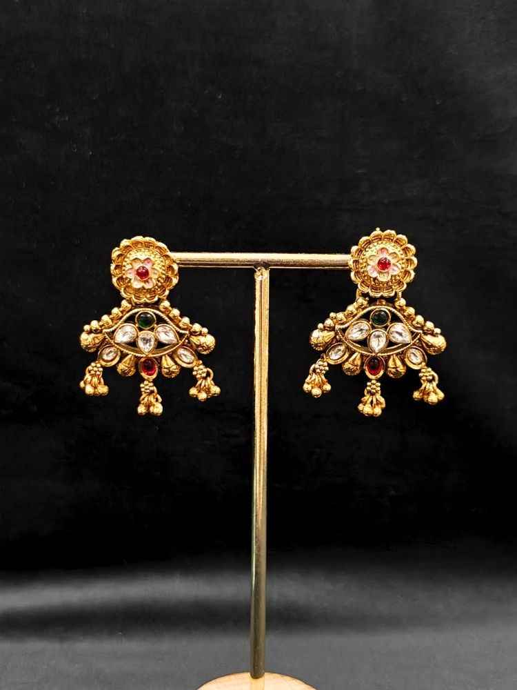 Close-up of an ornate traditional (Gold Polish) Collar jewellery set and earrings with Polki, Meenakari and Colored Stones. Festive Diwali outfit paired with a colorful Colored Stone necklace. Mehendi ceremony look completed with a Colored Stones jewelry set.