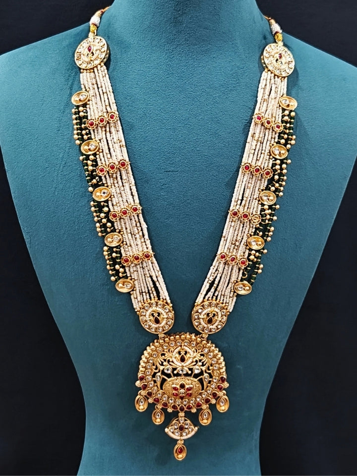 Close-up of an ornate traditional Rajwadi gold Long jewellery set and earrings  with  Pearls, Beads, Colored Stones, Bandhai Work and Kundan. Close-up of a Rajwadi artificial necklace for wedding celebrations. Close-up of a premium Rajwadi artificial necklace under 10000. 