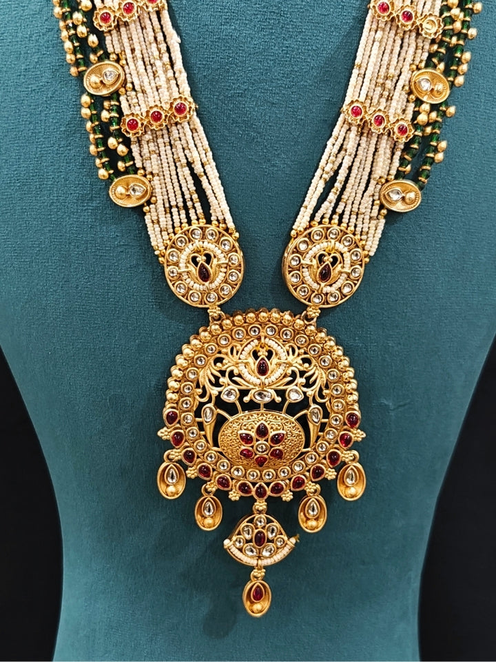 Close-up of an ornate traditional Rajwadi gold Long jewellery set and earrings  with  Pearls, Beads, Colored Stones, Bandhai Work and Kundan. Close-up of a Rajwadi artificial necklace for wedding celebrations. Close-up of a premium Rajwadi artificial necklace under 10000. 