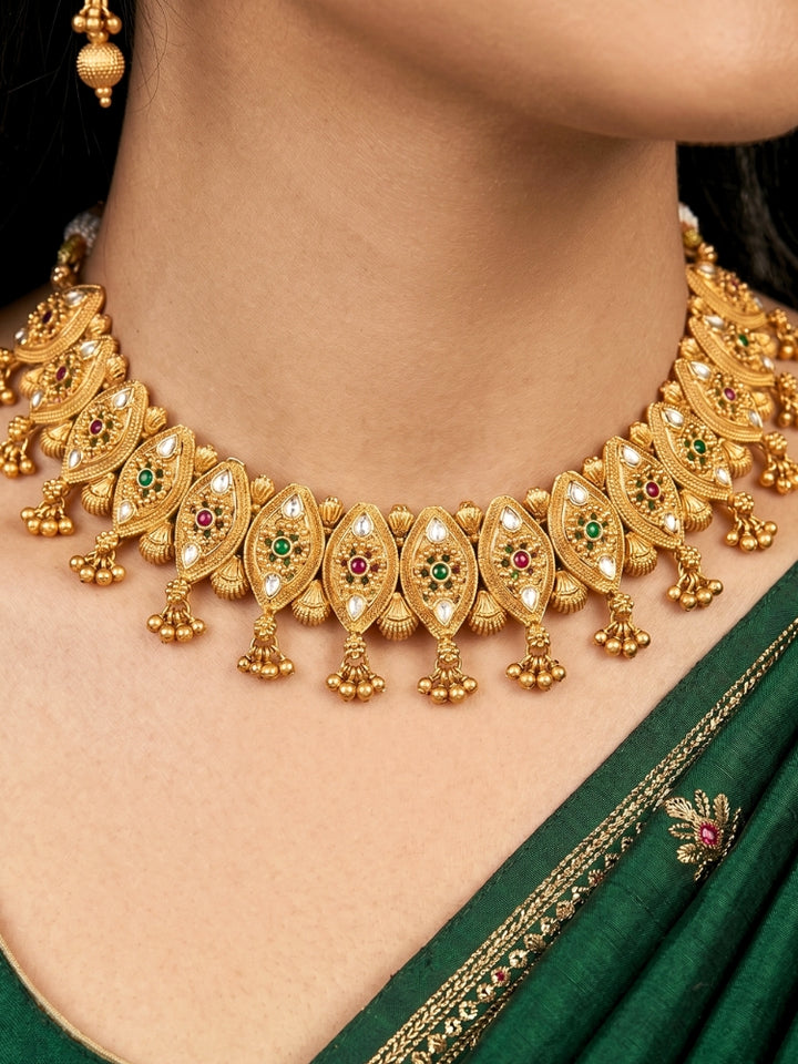 Close-up of an ornate traditional (Gold Polish) Collar jewellery set and earrings with Polki and Colored Stones. Elegant festive look with a high-quality imitation American diamond necklace set. Close-up shot of a high-quality American diamond artificial necklace worn for festive celebrations.