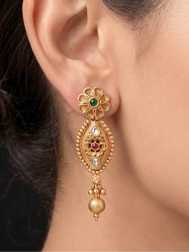 Close-up of an ornate traditional (Gold Polish) Collar jewellery set and earrings with Polki and Colored Stones. Elegant festive look with a high-quality imitation American diamond necklace set. Close-up shot of a high-quality American diamond artificial necklace worn for festive celebrations.