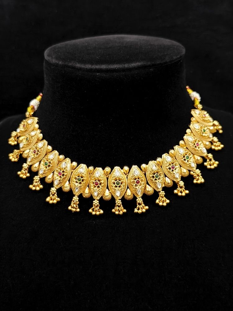 Close-up of an ornate traditional (Gold Polish) Collar jewellery set and earrings with Polki and Colored Stones. Elegant festive look with a high-quality imitation American diamond necklace set. Close-up shot of a high-quality American diamond artificial necklace worn for festive celebrations.
