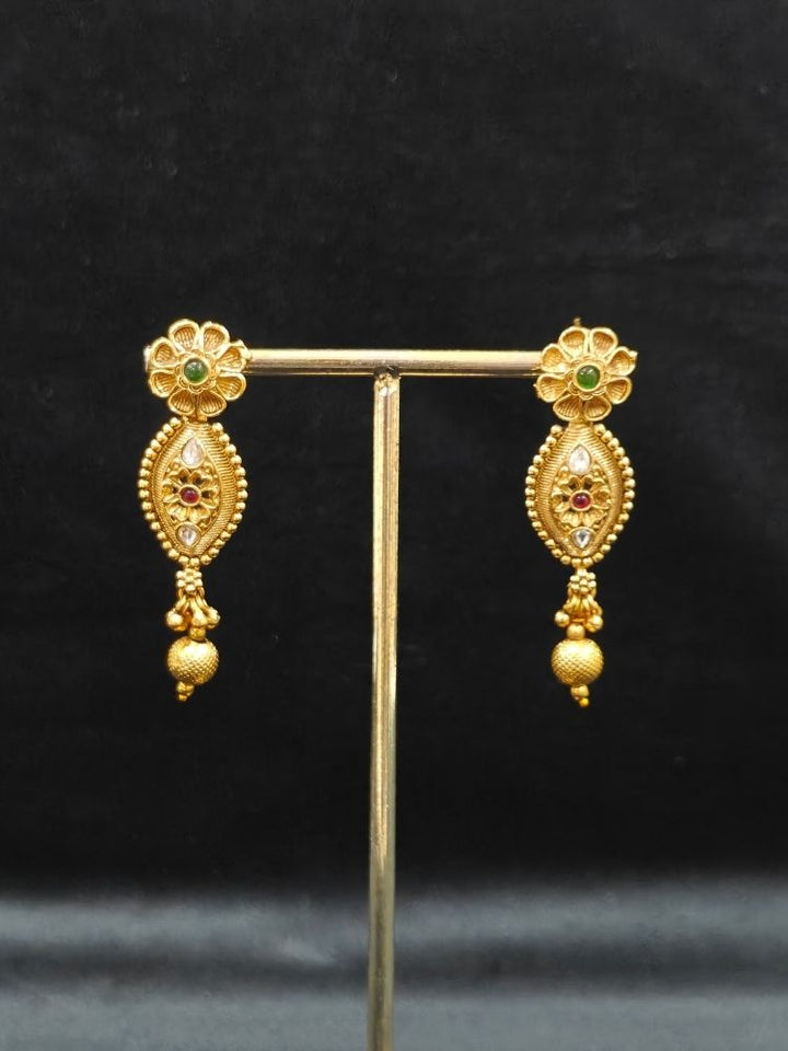 Close-up of an ornate traditional (Gold Polish) Collar jewellery set and earrings with Polki and Colored Stones. Elegant festive look with a high-quality imitation American diamond necklace set. Close-up shot of a high-quality American diamond artificial necklace worn for festive celebrations.