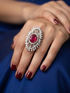 Close-up of a woman wearing an ornate Western (Silver Polish) Red Diamond Ring with American Diamond and Colored Stones. Cocktail party outfit paired with sparkling artificial American Diamond Ring. Close-up of American diamond Ring styled for a reception party.
