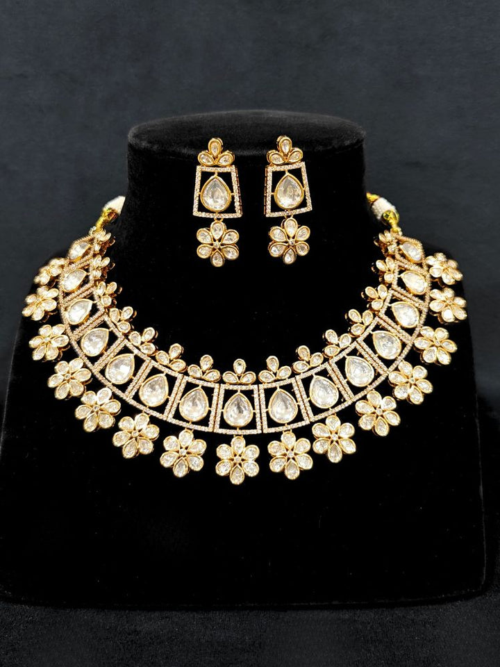 Close-up of an ornate traditional (Gold Polish) White Collar jewellery set and earrings with Polki and American Diamond. Reception-ready look featuring a sparkling Polki necklace set. Close-up of a cocktail party look featuring a premium American diamond necklace.