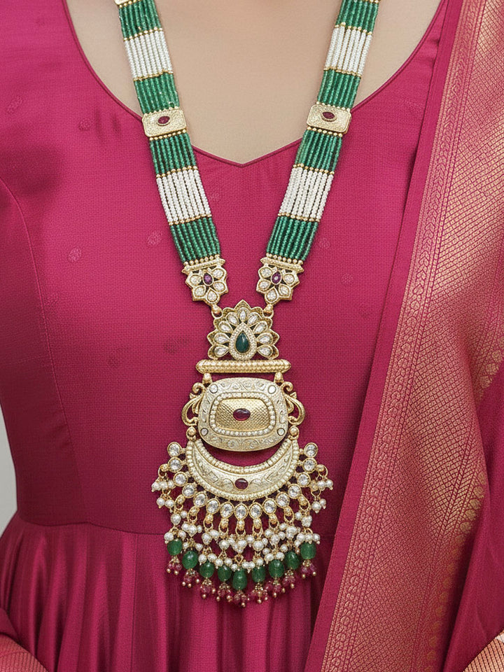 Close-up of a woman wearing an ornate traditional Mint Green Rajwadi gold Long jewellery set and earrings with Pearls, Tumble Beads, Meenakari, Hydro Crystal, Bandhai Work. Woman styled in a royal Rajwadi artificial necklace set for a traditional Indian wedding. Luxury imitation Rajwadi necklace worn for wedding celebrations.