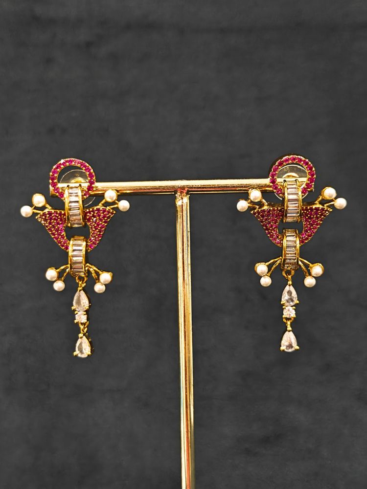 Close-up of an ornate Indo-Westerrn Pink Collar jewellery set and earrings with Pink Colored Stones, Baguette American Diamonds and Pearls. Reception party styling featuring a premium Colored Stones imitation set. Close-up of a cocktail party look featuring a premium Colored Stones necklace.