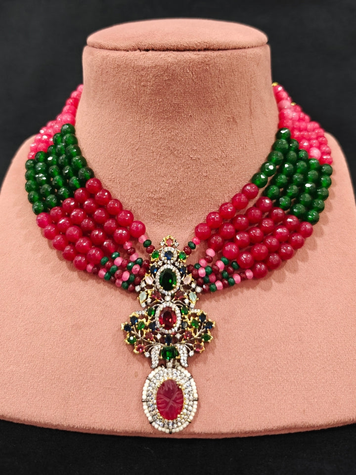 Close-up of a woman wearing an ornate traditional Colored Stones Multi-Color gold Collar jewellery set and earrings with Colored Beads, Colored Stones and American Diamond. A luxury Colored Stones necklace set styled beautifully for a wedding guest look in India. Elegant festive look with a high-quality imitation Colored Stones necklace set.