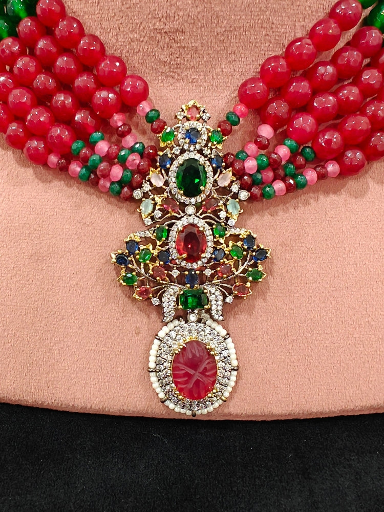 Close-up of a woman wearing an ornate traditional Colored Stones Multi-Color gold Collar jewellery set and earrings with Colored Beads, Colored Stones and American Diamond. A luxury Colored Stones necklace set styled beautifully for a wedding guest look in India. Elegant festive look with a high-quality imitation Colored Stones necklace set.