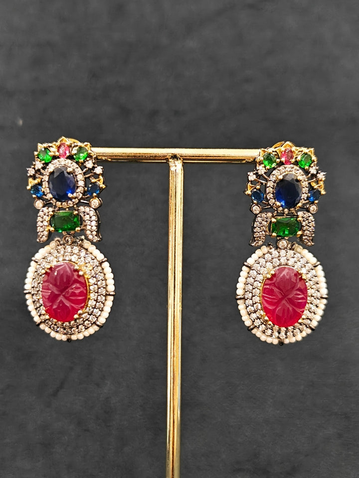 Close-up of a woman wearing an ornate traditional Colored Stones Multi-Color gold Collar jewellery set and earrings with Colored Beads, Colored Stones and American Diamond. A luxury Colored Stones necklace set styled beautifully for a wedding guest look in India. Elegant festive look with a high-quality imitation Colored Stones necklace set.