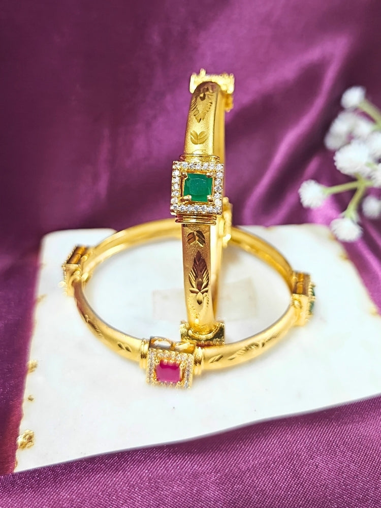 Close-up of an ornate traditional (Gold Polish) Bangles Set with American Diamond and Pink & Green Colored Stone. Festive celebration look enhanced with artificial Colored Stone bangles. Close-up of premium imitation Colored Stone bangles styled with a silk saree.