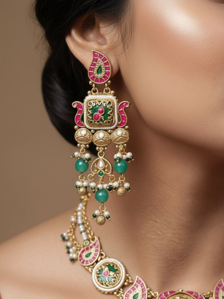 Close-up of a woman wearing an ornate traditional (Gold Polish) Pink & Mint Green Collar jewellery set and earrings and with Enamel and Pearls. Wedding celebration look featuring a premium heritage artificial set. Woman wearing a heritage-style artificial necklace for long wedding functions.