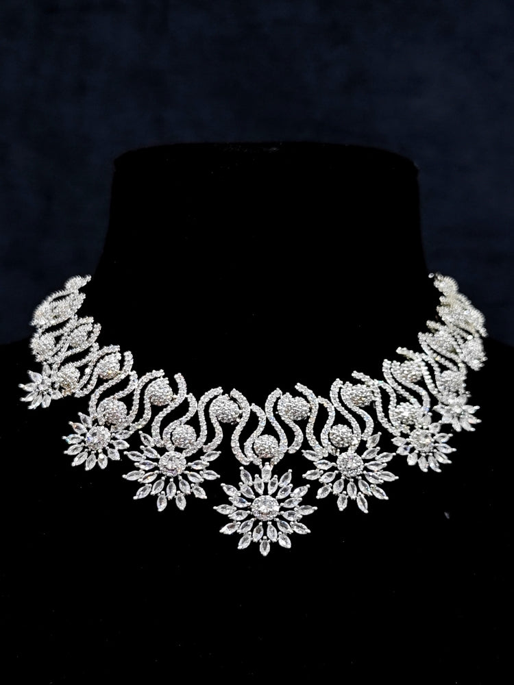 Close-up of an ornate Indo-western American Diamond Silver Collar jewellery set and earrings and maangtikka with American Diamond. A woman wearing a luxury American diamond necklace set styled beautifully for a wedding guest look in India. Reception-ready look featuring a statement American diamond jewelry set.