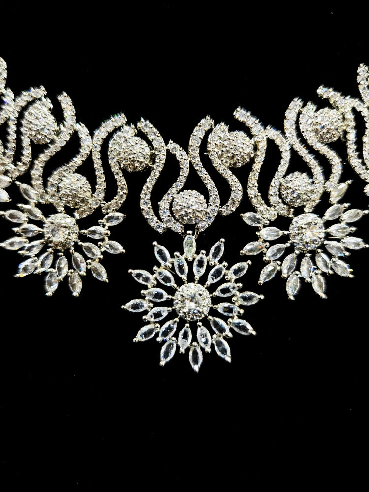Close-up of an ornate Indo-western American Diamond Silver Collar jewellery set and earrings and maangtikka with American Diamond. A woman wearing a luxury American diamond necklace set styled beautifully for a wedding guest look in India. Reception-ready look featuring a statement American diamond jewelry set.