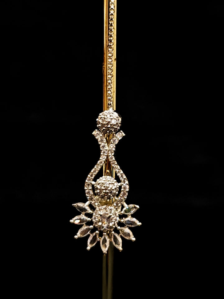 Close-up of an ornate Indo-western American Diamond Silver Collar jewellery set and earrings and maangtikka with American Diamond. A woman wearing a luxury American diamond necklace set styled beautifully for a wedding guest look in India. Reception-ready look featuring a statement American diamond jewelry set.