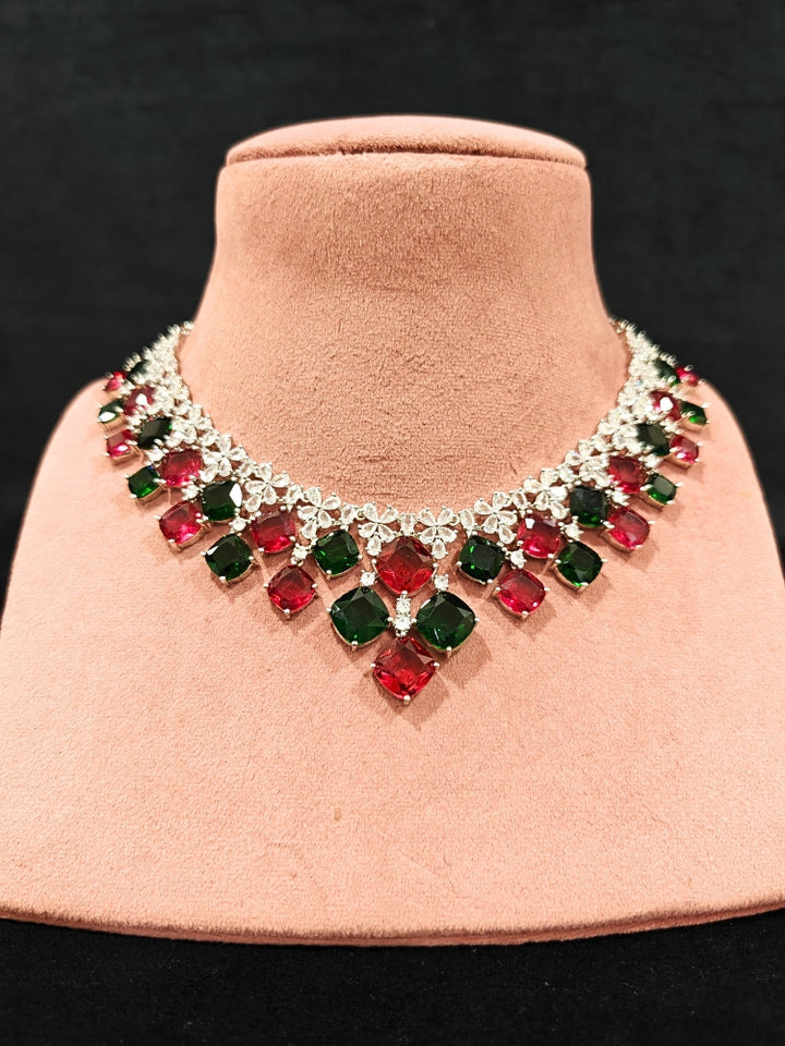 An exquisite artificial diamond and red and green colored stone necklace and matching earrings, designed for the perfect engagement look. This stunning artificial diamond jewelry set offers luxury and sophistication while being an affordable alternative to natural diamonds.
