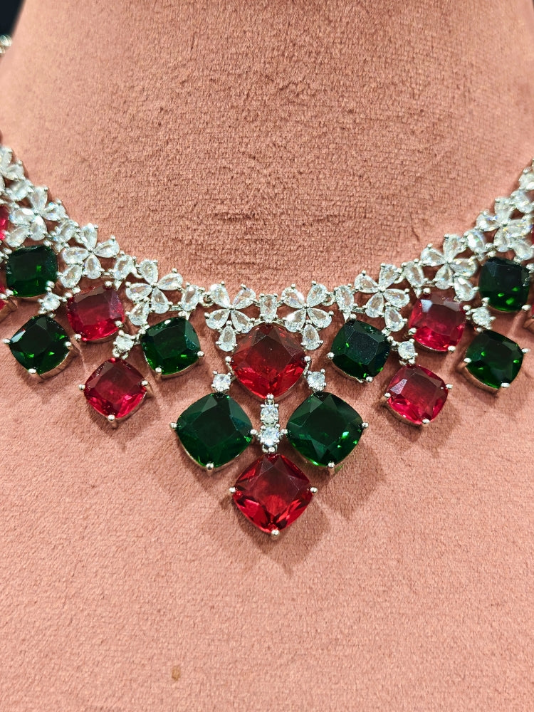 An exquisite artificial diamond and red and green colored stone necklace and matching earrings, designed for the perfect engagement look. This stunning artificial diamond jewelry set offers luxury and sophistication while being an affordable alternative to natural diamonds.