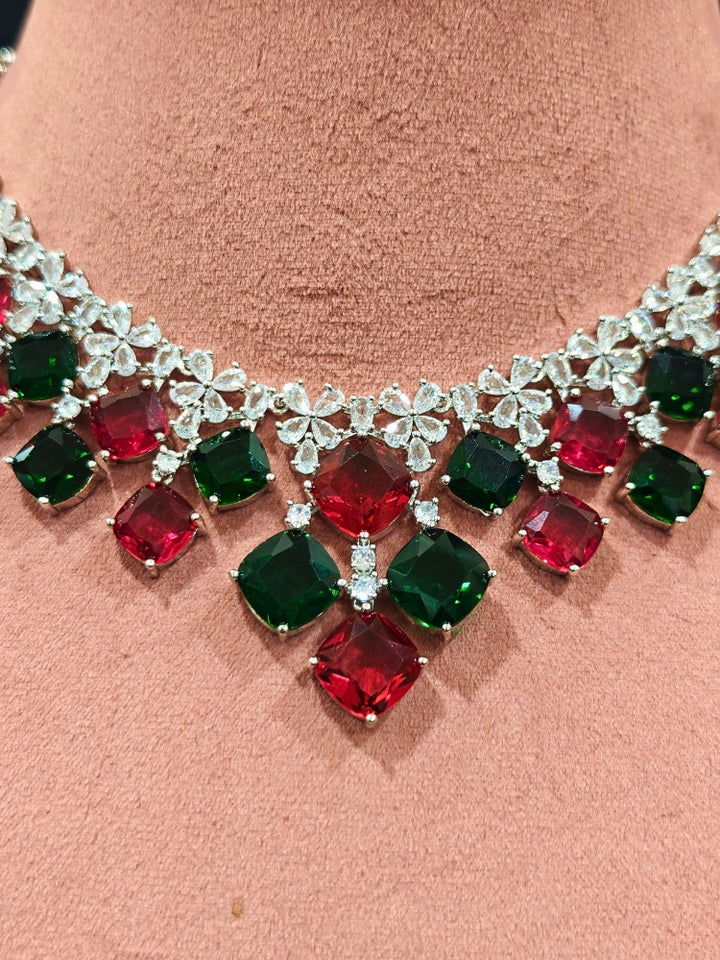 An exquisite artificial diamond and red and green colored stone necklace and matching earrings, designed for the perfect engagement look. This stunning artificial diamond jewelry set offers luxury and sophistication while being an affordable alternative to natural diamonds.