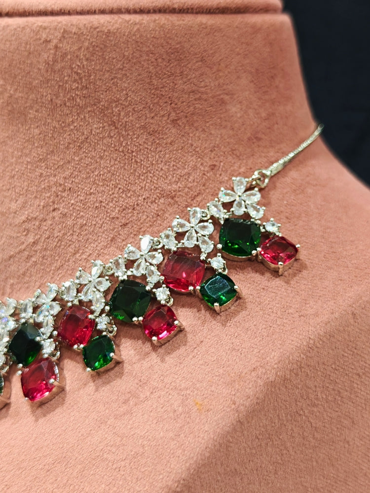 An exquisite artificial diamond and red and green colored stone necklace and matching earrings, designed for the perfect engagement look. This stunning artificial diamond jewelry set offers luxury and sophistication while being an affordable alternative to natural diamonds.