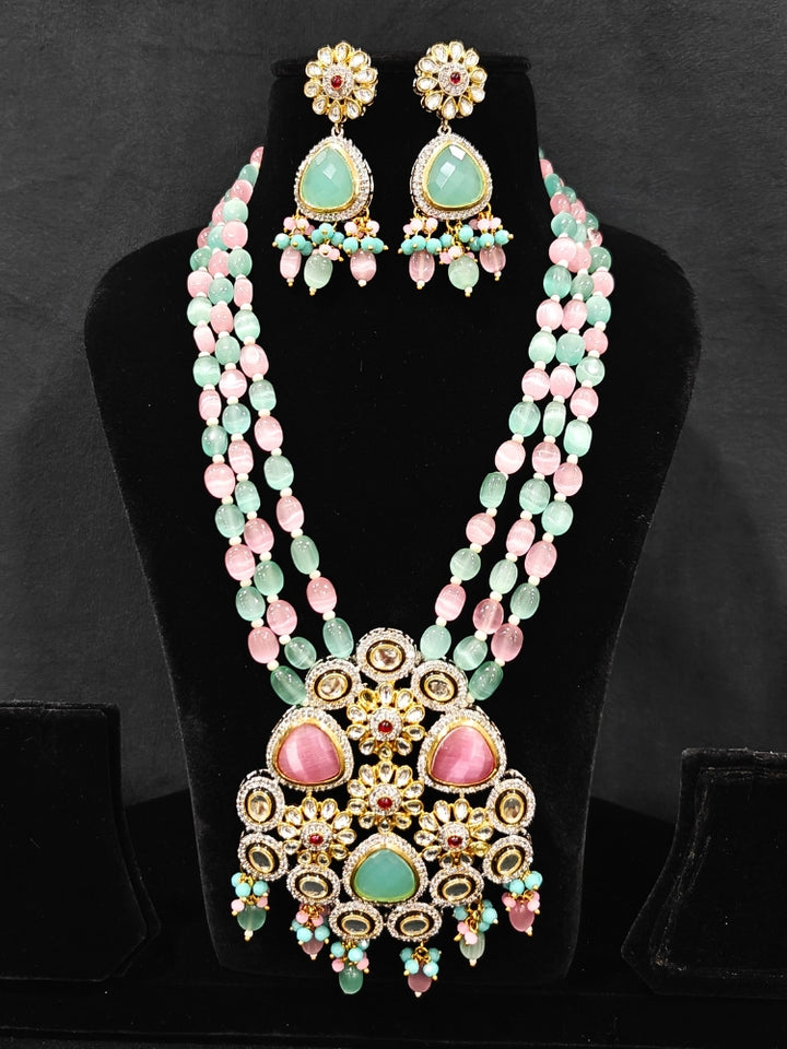 Close-up of an ornate traditional Mint Green and Pink Long jewellery set and earrings with American Diamond, Kundan, Tumble & Crystal Beads, Pearls, Tyaani Kundan and Monalisa Stone. A trending Colored Stone artificial jewelry for wedding season in India. Festive saree styling with a premium artificial Colored Stone necklace.