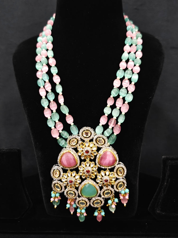 Close-up of an ornate traditional Mint Green and Pink Long jewellery set and earrings with American Diamond, Kundan, Tumble & Crystal Beads, Pearls, Tyaani Kundan and Monalisa Stone. A trending Colored Stone artificial jewelry for wedding season in India. Festive saree styling with a premium artificial Colored Stone necklace.