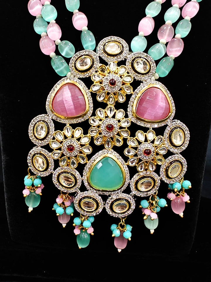 Close-up of an ornate traditional Mint Green and Pink Long jewellery set and earrings with American Diamond, Kundan, Tumble & Crystal Beads, Pearls, Tyaani Kundan and Monalisa Stone. A trending Colored Stone artificial jewelry for wedding season in India. Festive saree styling with a premium artificial Colored Stone necklace.