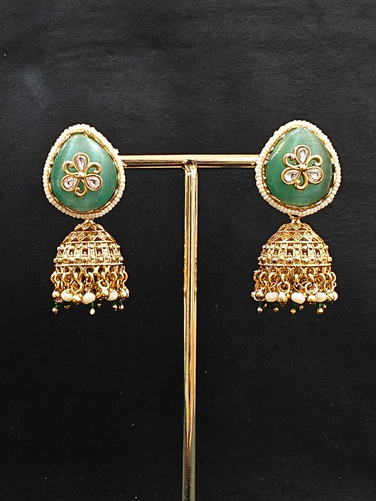 Close-up of an ornate traditional Mint Green Heritage gold Collar jewellery set and earrings with Mint Green Colored Stones, Kundan and Pearls. Woman styling a vintage heritage artificial necklace for a reception party. Perfect  Heritage necklace set for weddings and festivals.