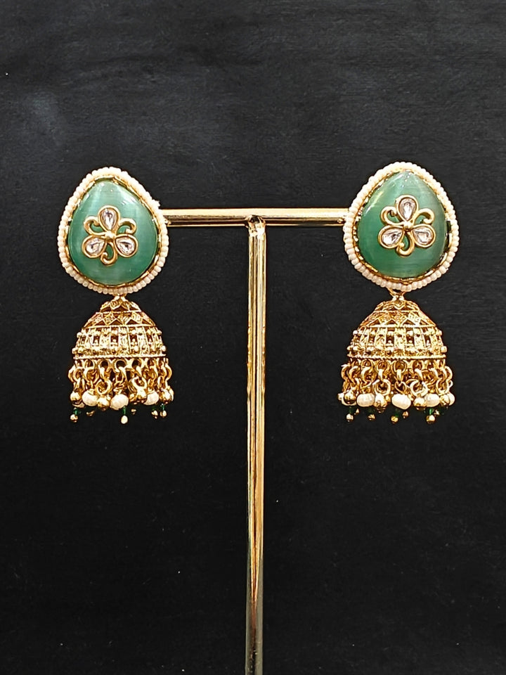 Close-up of an ornate traditional Mint Green Heritage gold Collar jewellery set and earrings with Mint Green Colored Stones, Kundan and Pearls. Woman styling a vintage heritage artificial necklace for a reception party. Perfect  Heritage necklace set for weddings and festivals.