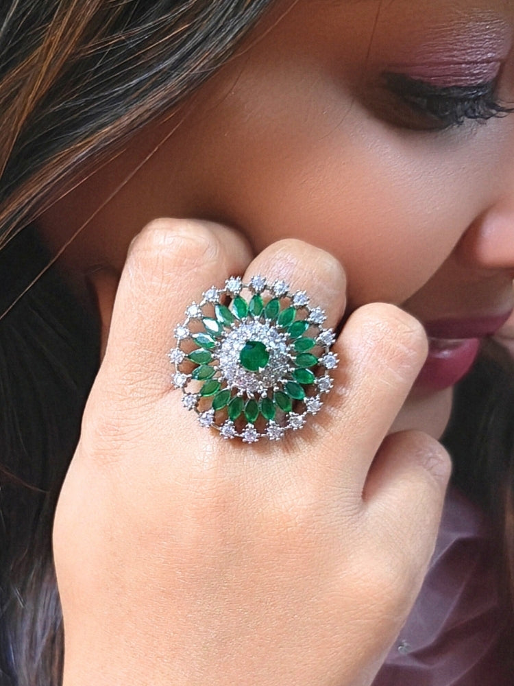 Close-up of a woman wearing an ornate Indo-Western (Silver Polish) Green Diamond Ring with American Diamond and Green Colored Stones. Close-up of an American diamond cocktail ring for party wear in India. Wedding guest wearing a statement artificial American Diamond cocktail ring.
