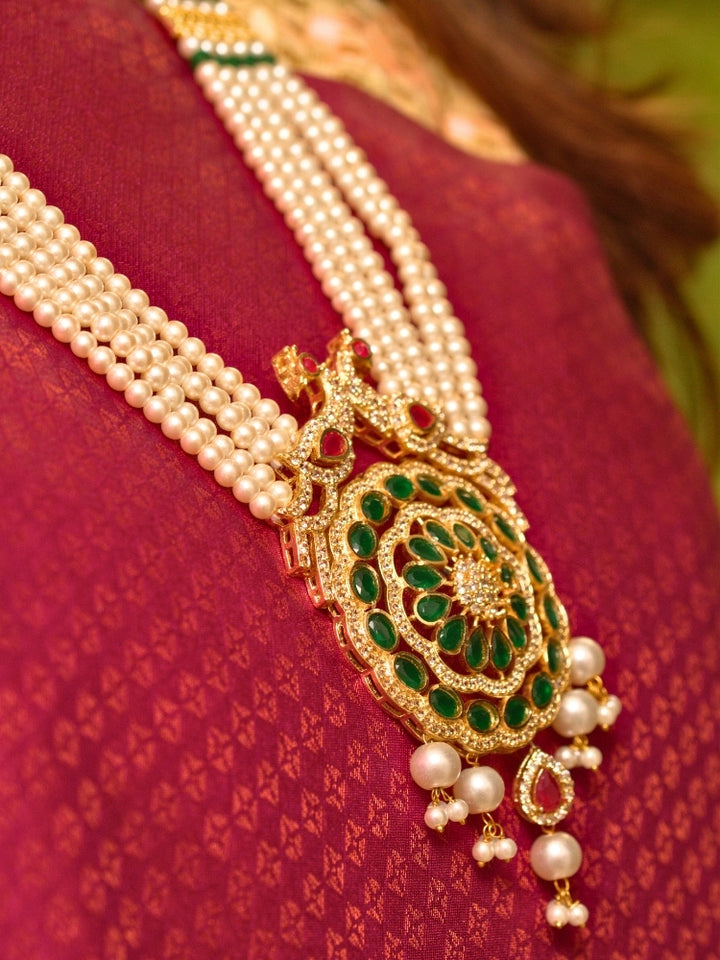 Close-up of a woman wearing an ornate traditional (Gold Polish) White Long Jewellery Set and Earrings with Colored Stones, Pearl and American Dimaonds.  Wedding guest wearing a lightweight Kundan necklace for a Wedding function. Woman wearing trending Pearl artificial jewelry for wedding season in India.
