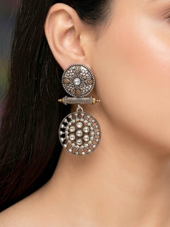 Close-up of a woman wearing an ornate traditional (Dual Tone Polish) White Oxidised Earrings set with Kundan. Festive celebration look enhanced with sparkling artificial Oxidised Earrings. Saree look completed with elegant artificial Earrings set for festive occasions.