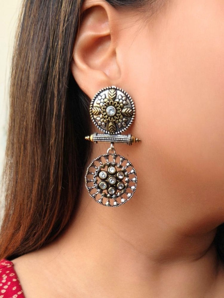 Close-up of a woman wearing an ornate traditional (Dual Tone Polish) White Oxidised Earrings set with Kundan. Festive celebration look enhanced with sparkling artificial Oxidised Earrings. Saree look completed with elegant artificial Earrings set for festive occasions.