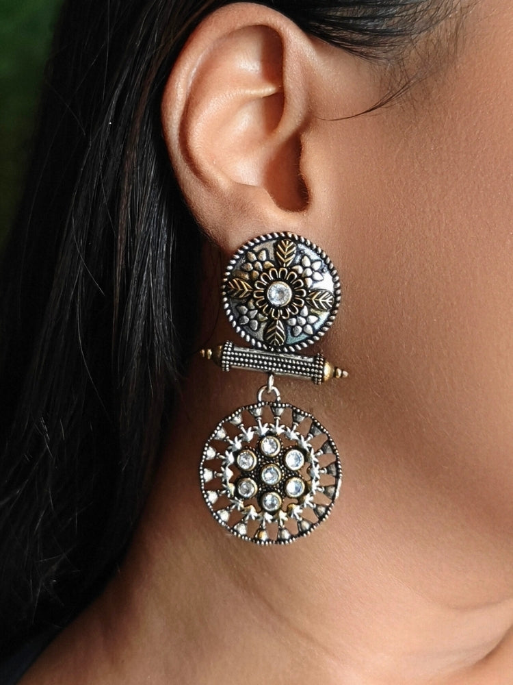 Close-up of a woman wearing an ornate traditional (Dual Tone Polish) White Oxidised Earrings set with Kundan. Festive celebration look enhanced with sparkling artificial Oxidised Earrings. Saree look completed with elegant artificial Earrings set for festive occasions.