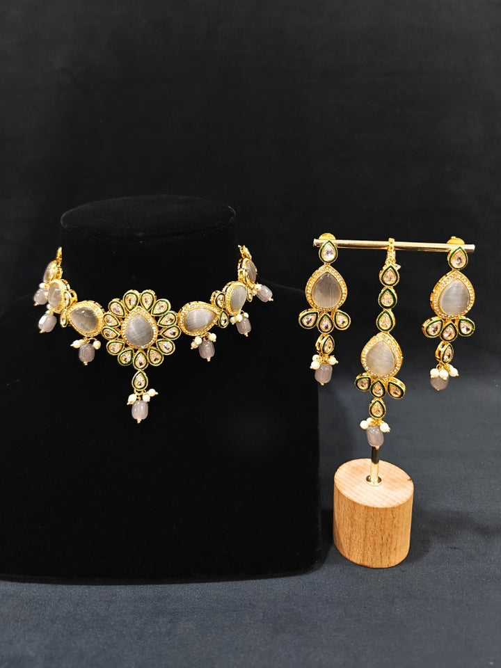 Close-up of an ornate traditional Whitish Grey Choker jewellery set and earrings and maangtikka with Kundan, Monalisa Stone, American Diamonds, Beads and Reverse American Diamonds and tumble stones. A graceful woman wearing a trending Colored Stone necklace for a 2026 wedding celebration. Elegant wedding jewelry look featuring a premium artificial Colored Stone necklace.