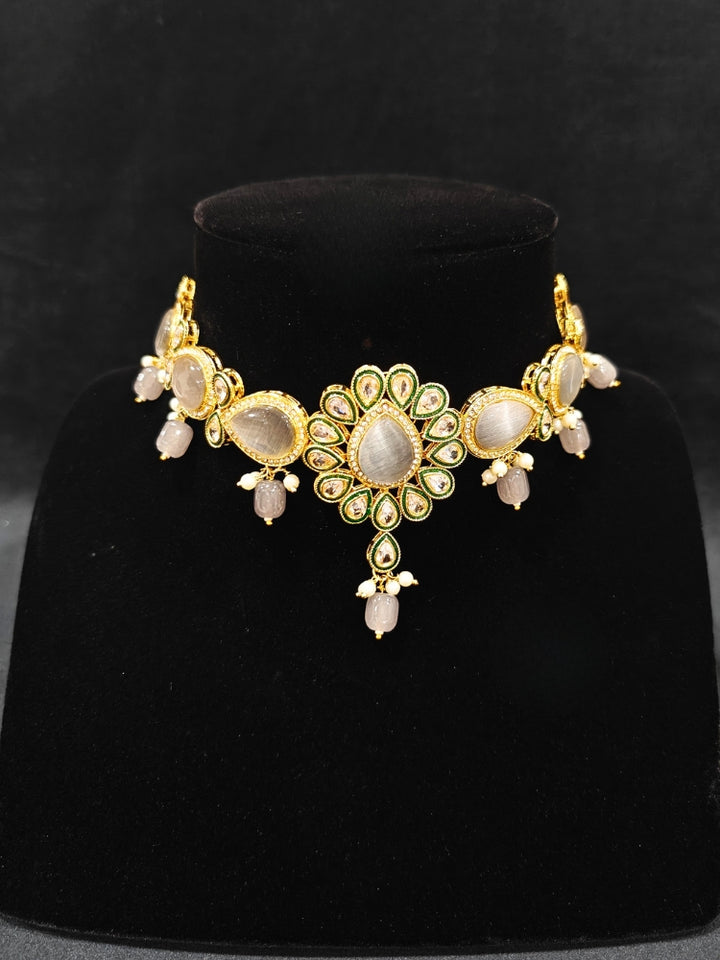 Close-up of an ornate traditional Whitish Grey Choker jewellery set and earrings and maangtikka with Kundan, Monalisa Stone, American Diamonds, Beads and Reverse American Diamonds and tumble stones. A graceful woman wearing a trending Colored Stone necklace for a 2026 wedding celebration. Elegant wedding jewelry look featuring a premium artificial Colored Stone necklace.