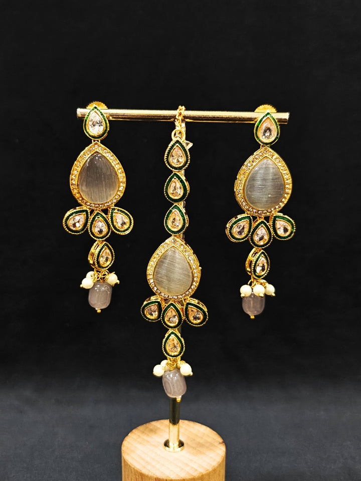 Close-up of an ornate traditional Whitish Grey Choker jewellery set and earrings and maangtikka with Kundan, Monalisa Stone, American Diamonds, Beads and Reverse American Diamonds and tumble stones. A graceful woman wearing a trending Colored Stone necklace for a 2026 wedding celebration. Elegant wedding jewelry look featuring a premium artificial Colored Stone necklace.