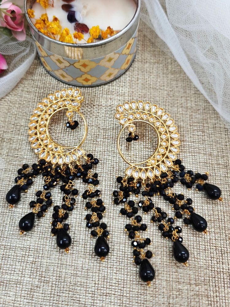 Close-up of ornate traditional (Gold Polish) Black Long  Earrings with Kundan and Black Beads. Mehendi ceremony look completed with a handcrafted Kundan Earrings. Wedding celebration look enhanced with a statement Kundan Earrings.